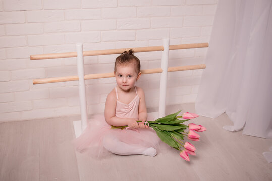 Ballet teacher and little ballerina have practice in dance class.little beautiful girl is doing ballet