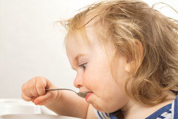 feeds baby boy with a spoon porridge