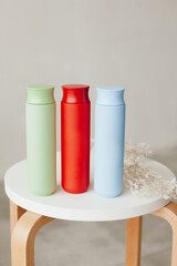 three jars of blue, green and red stand on the table on a white background. containers for shampoo or cream. hair and skin care.