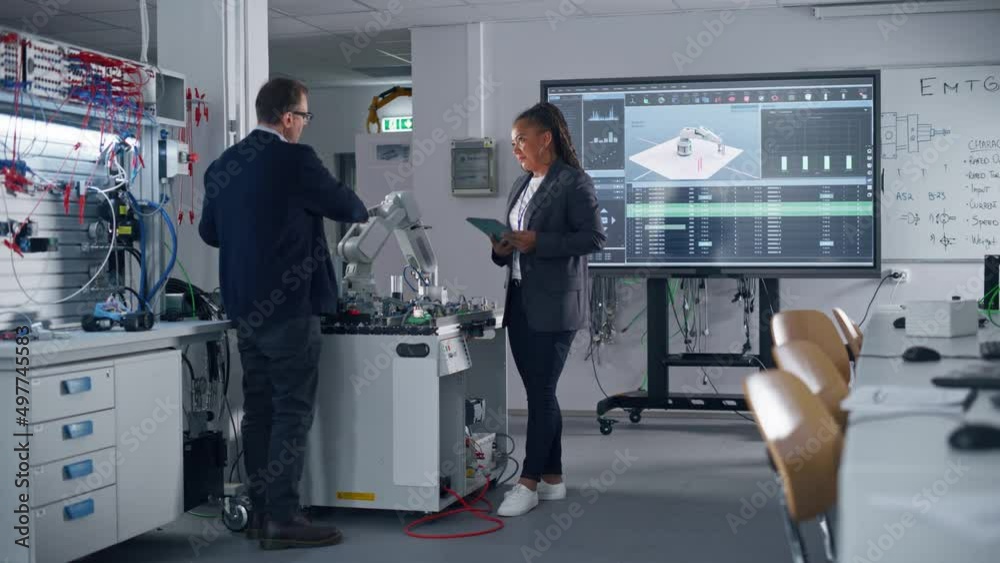 Poster Diverse Colleagues Standing Near Table With Robot Arm, They Discussing with Each Other with Laptop and Tablet Devices in Hands. Bright Facility, Creative People Concept
