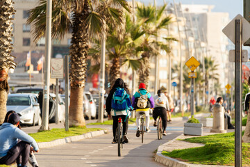Fototapeta na wymiar unknown people commuting by bike in the street of La Serena