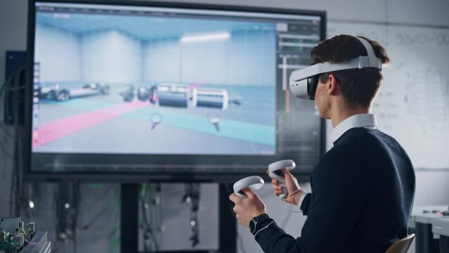 Student Male Engineer Wearing AR Headset Designs Prototype of Electric Motor on the Big Screen while Using Controllers. Futuristic Virtual Design of Mixed Technology Application Concept