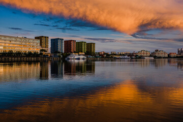 Fototapeta premium MOSCOW, RUSSIA - AUGUST 5, 2018: View of modern buildings near the water during sunset
