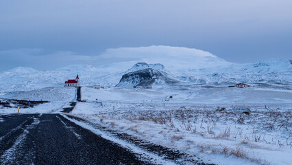 Malerische Winterlandschaft mit einsamer Kirche vor Gletscher und Bergen