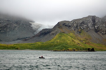 Glacier between two hills, under low hanging clouds, at Coopers Bay, South Georgia Island