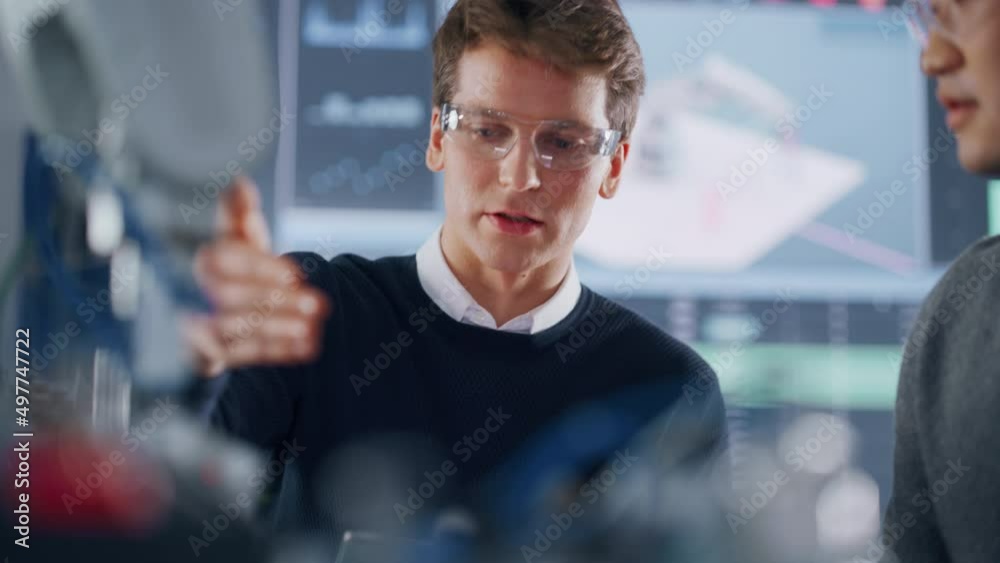 Poster asian development engineer student brainstorming with his caucasian classmate in a high tech researc