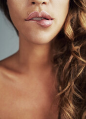 Love your lips. Cropped shot of a young woman biting her lips.