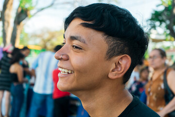 Portrait of a latin young man smiling and enjoying himself in a park