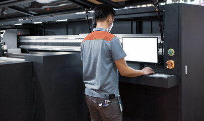 Fototapeta na wymiar Industrial technician operating corrugated cardboard digital inkjet printer. Printing industry.