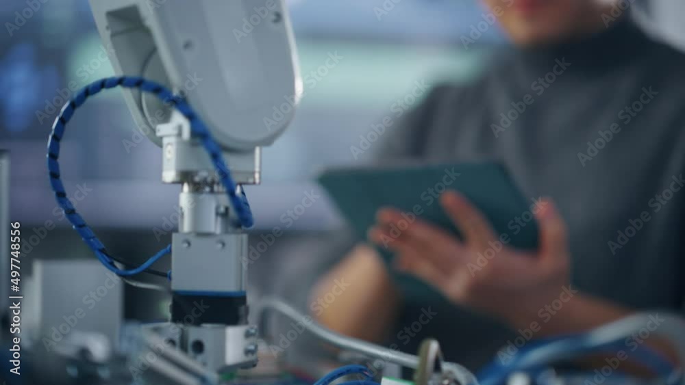 Leinwandbilder Male Student Typing at Tablet while Programming Bionic Claw At Factory. Robot is Moving Under his Control. Young Developer in Robotics Facility Working on Software Production. Close Up View