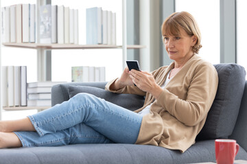 Obraz premium senior woman using smartphone for work in free time