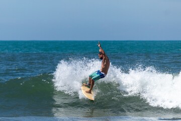 SURFISTA FAZENDO MANOBRA NA ONDA.