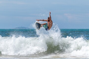 SURFISTA FAZENDO UMA MANOBRA AERIA.