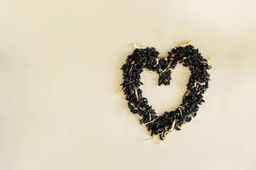 black ceylon tea scattered in the shape of a heart on a craft substrate