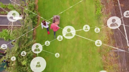 Network of profile icons against aerial view of caucasian couple with garden cart in the garden