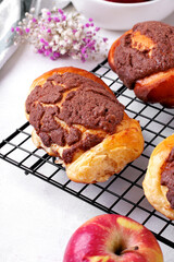 Roll bun, Concha, of Mexican cuisine with apple filling on the cooling rack on white table. Yeast and shortbread pastry