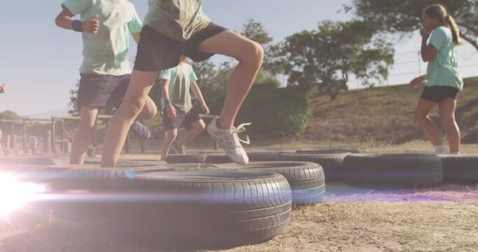 Animation of light spots over diverse schoolchildren exercising on obstacle course