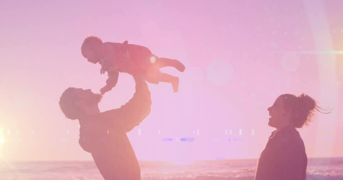 Animation of light spots over happy caucasian couple with baby at beach