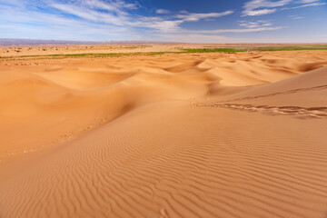 Fototapeta na wymiar Paesaggio desertico con dune di sabbia alte e sfondo cielo blu