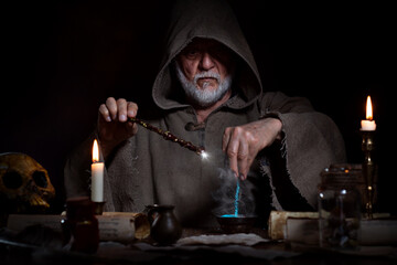 Old wizard conjures up elixir with magic wand