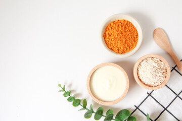 Natural ingredients for homemade face mask, top view of yoghurt, oat and turmeric on white background, beauty skincare product concept, flat lay