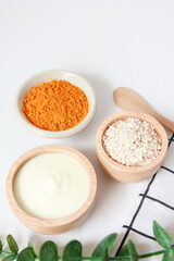 Obraz na płótnie Canvas Natural ingredients for homemade face mask, top view of yoghurt, oat and turmeric on white background, beauty skincare product concept, flat lay
