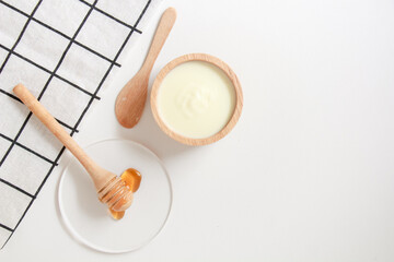 Natural ingredients for homemade face mask, top view of yoghurt and honey on white background, beauty skincare product concept, flat lay