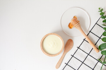 Natural ingredients for homemade face mask, top view of yoghurt and honey on white background, beauty skincare product concept, flat lay