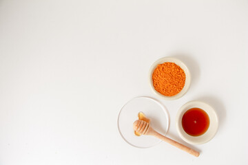 Natural ingredients for homemade face mask, top view of turmeric and honey on white background, beauty skincare product concept, flat lay