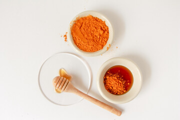 Natural ingredients for homemade face mask, top view of turmeric and honey on white background, beauty skincare product concept, flat lay