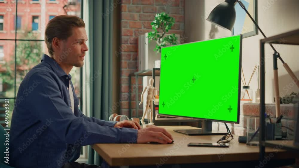 Aufkleber young handsome man working from home on desktop computer with green screen mock up display. male che