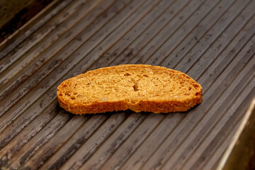 Cook roasts slices of bread on the grill