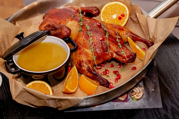 Duck baked with apples and oranges lies on the board