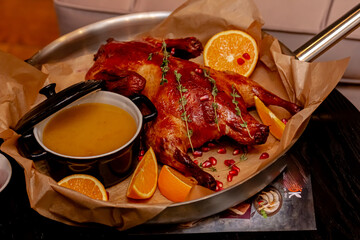 Duck baked with apples and oranges lies on the board
