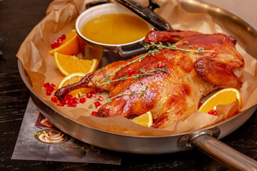 Duck baked with apples and oranges lies on the board
