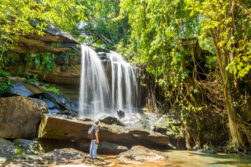 Wonderful freshwater waterfall in the forest. Fresh nature, tourists watching the beauty of the waterfall.