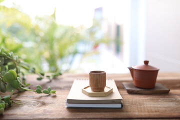 Wooden tea cup and tea pot on wooden table