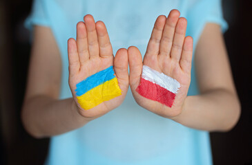 Child's hands painted in flags colors. Ukraine and Poland. Poland helps Ukraine. Friendship symbol....