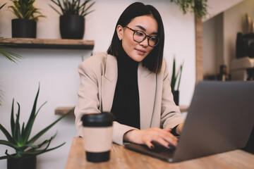 Asian businesswoman working on laptop in cafe