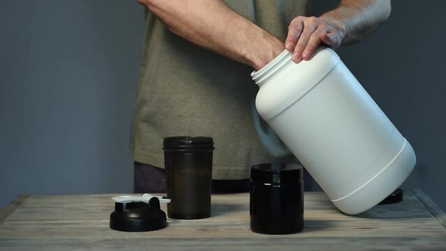 The athlete pours protein into a shaker. The concept of sports nutrition.