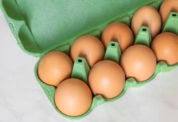 brown chicken eggs in green eco cardboard egg tray