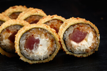 Hot fried sushi roll with salmon. Sushi menu. Japanese food. Hot fried sushi roll on black background