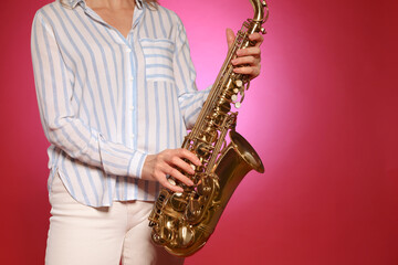 Fototapeta na wymiar Woman with saxophone on red background, closeup. Space for text