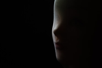 A girl doll isolated on black background with copy space.