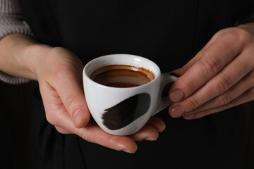 Woman holding cup of fresh aromatic espresso, closeup