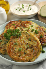 Delicious zucchini fritters served on table, closeup
