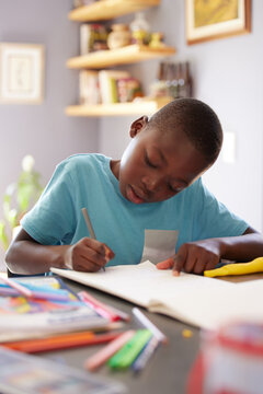 I could spend all day colouring in pictures. Shot of a young boy spending his time colouring in pictures.