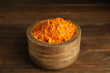 Aromatic saffron powder in bowl on wooden table