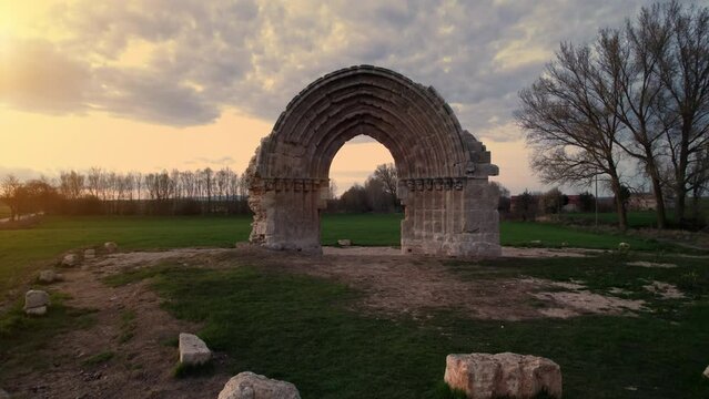 Drone Flying Through a medieval Arch to Reveal a Scenic meadow landscape at dusk in Sasamon, Castile and Leon, Spain. High quality 4k footage
