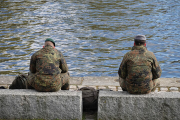 zwei uniformierte Soldaten sitzen am Kanal
